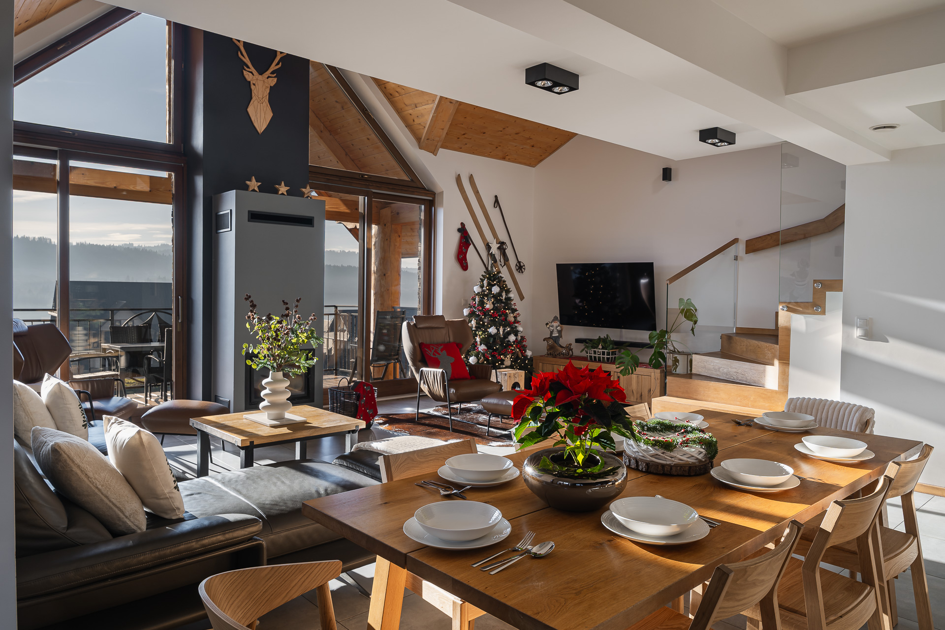 Przytulny salon w stylu chalet z kominkiem i widokiem na Jezioro Czorsztyńskie w apartamencie w Kluszkowcach. Sezonowość w fotografii wnętrz.