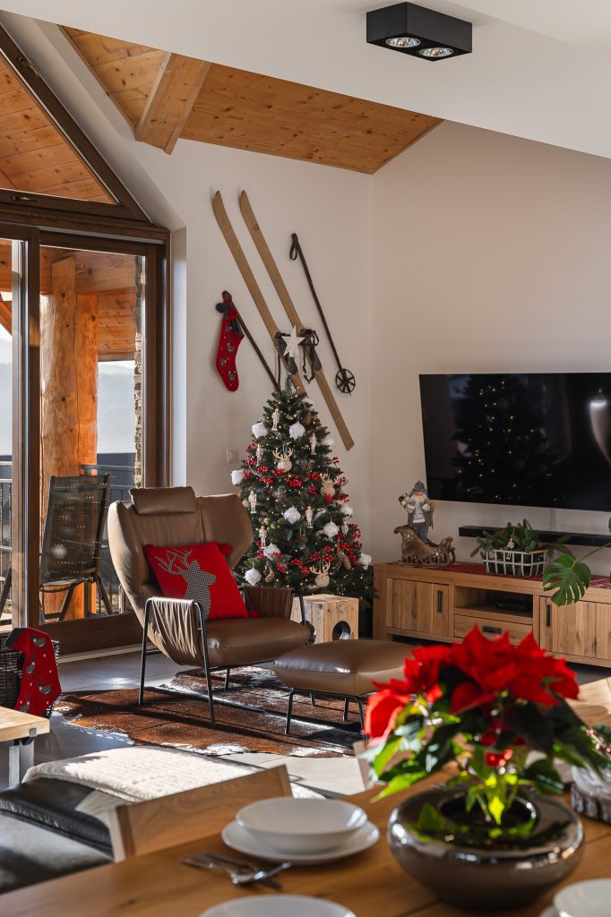 Przytulny salon w stylu chalet z kominkiem i widokiem na Jezioro Czorsztyńskie. Sezonowość w fotografii wnętrz.